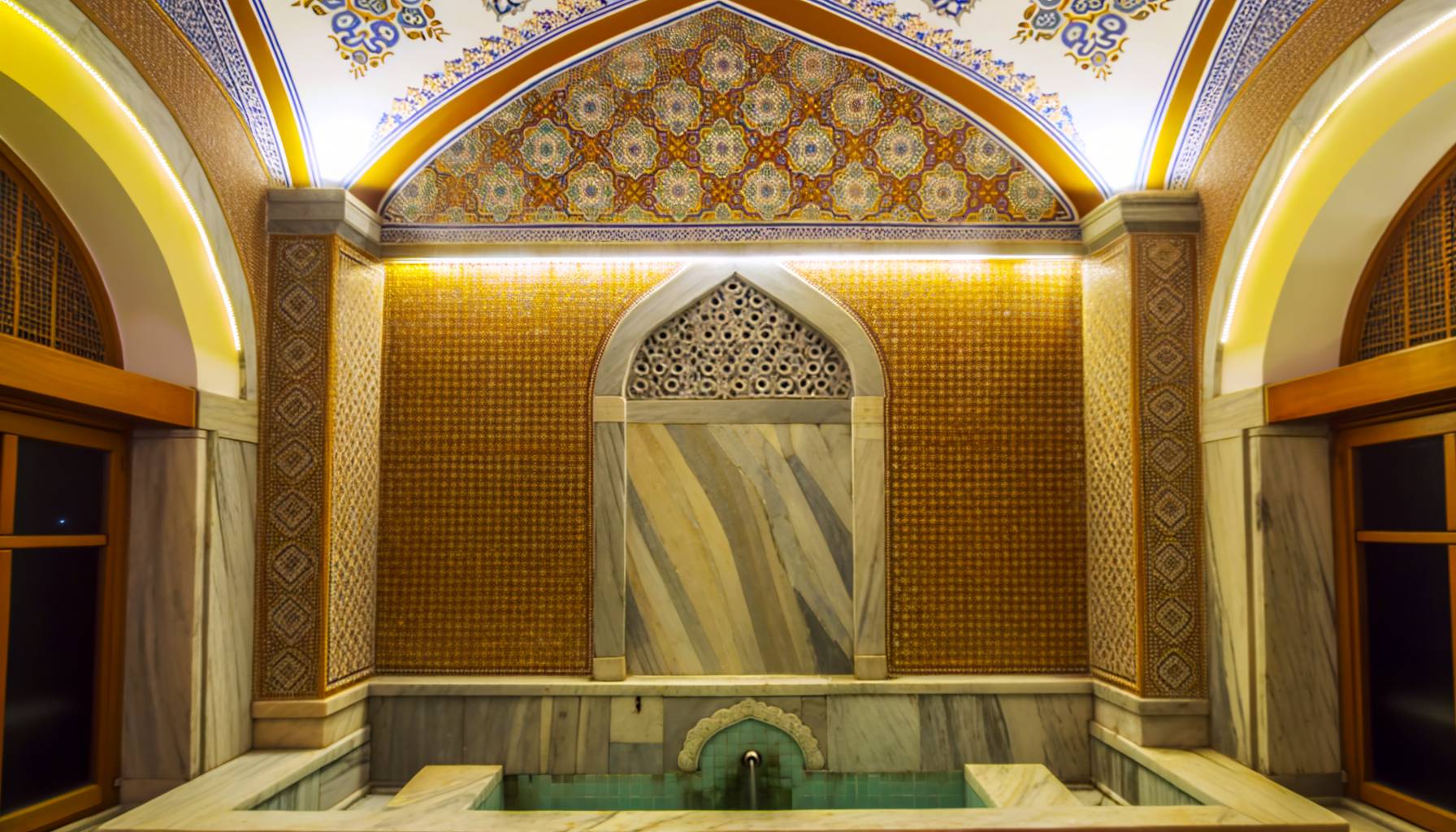 Un baño turco tradicional con diseño arquitectónico otomano, mostrando mosaicos coloridos y detal...